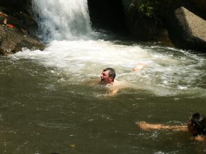 Schwimmen an Wasserfall in den Bergen von